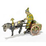 A mid to late 20th century German clockwork toy depicting a clown riding a cart pulled by a mule,