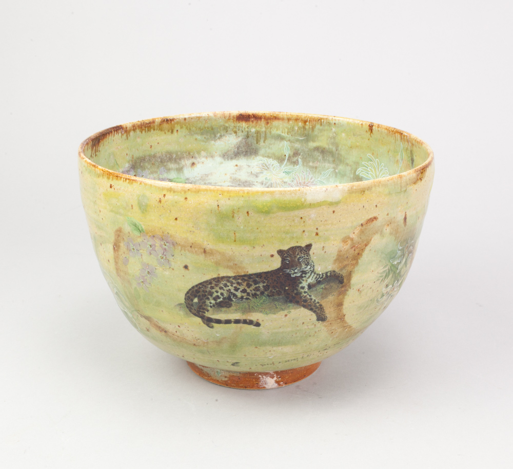ANDREW CHAMBERS; a deep stoneware bowl covered in green glaze with decals of a parrot, leopard and