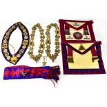 A small brown vintage case containing a quantity of Masonic regalia to include aprons, sash,