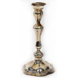 A George V hallmarked silver candlestick of lobed inverted baluster form,