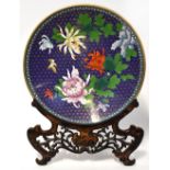 A Chinese cloisonné charger depicting a bird flying amongst chrysanthemums on dark blue ground