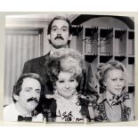 FAWLTY TOWERS; a black and white photograph bearing the signatures of the four stars, 20.5 x 25.5cm.