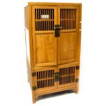 A 20th century Korean-style hardwood side cabinet with pair of part panelled doors above a further