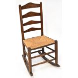 A 19th century rush seated country made ladder back rocking chair.