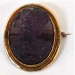 A late 19th/early 20th century amethyst-coloured glass cameo of young woman in period costume,