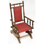 A late 19th/early 20th century child's bobbin turned rocking chair with upholstered seat and back.