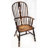 A 19th century country made spindle back Windsor elbow chair raised on turned and stretchered