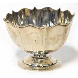 An Edwardian hallmarked silver bowl of faceted form with serpentine top, on a stepped circular base,