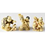 Three Japanese netsuke comprising a man releasing or capturing a bird while holding a cage,