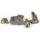 A group of four Inuit soapstone carvings comprising a group of two standing figures on a base one