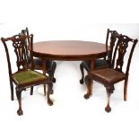 A reproduction mahogany extending dining table containing a single pop-up leaf,