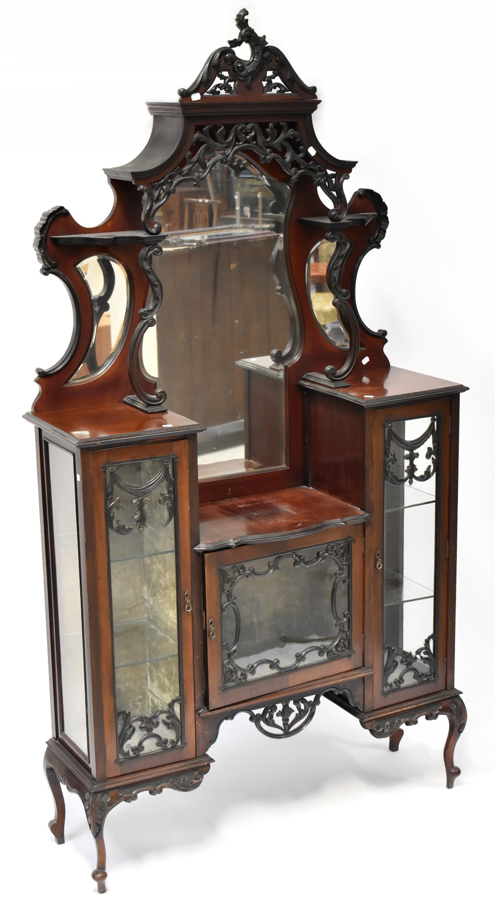 A Victorian mahogany mirror back display cabinet, shaped mirror above heavily carved canopy,