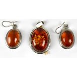 A hallmarked silver pendant set with oval amber and a pair of similar drop earrings (2).