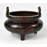 A Chinese bronze censer of squat form with twin rope twist style handles,