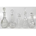 A group of five non-matching cut glass and crystal decanters to include a Victorian example with