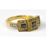 A 9ct gold ring set with three square cut blue diamonds (heat treated),