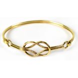 A 9ct gold bangle in the form of a Celtic knot with loop clasp, stamped 375, approx 15.7g.