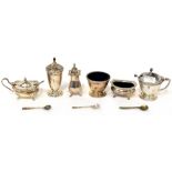 A George V hallmarked silver cruet set of squat baluster form, comprising a pepperette,