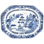 A Chinese Export blue and white meat plate painted with pagodas and a house within a lakeside scene,