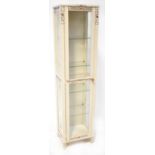 A modern white painted display cabinet, later decorated with gilt foliate scrollwork,