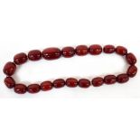 A string of twenty-one graduated burgundy/cherry Bakelite beads, sizes from 2.5cm to 3.5cm.