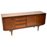 A mid-20th century teak sideboard comprising three cupboard doors, one drop-down,