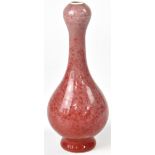 A Chinese vase of baluster form with red pink hare's fur glaze, raised on a circular foot,