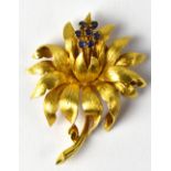 An 18ct yellow gold floral brooch set with blue stones, stamped '18' and '750', height 5cm, width 3.
