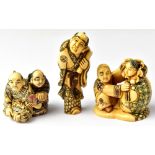 Three Japanese carved netsuke comprising a scholar holding a scroll,