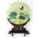 A Chinese circular jadeite panel set with hardstones depicting a scene with ducks lily pads and