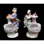 MEISSEN; a pair of figural table salts with puce heightened scalloped bowls each surmounted with a