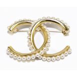 ***WITHDRAWN*** CHANEL; a vintage 1970s faux pearl CC interlinked gold tone brooch, signed Chanel,