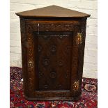 A late George III oak hanging corner cupboard.