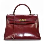 HERMES; a vintage 1962 burgundy leather Kelly 32 handbag, with a D-shaped handle and detachable
