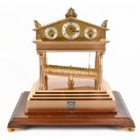 THWAITES & REED; a large and impressive gilt metal rolling ball clock of architectural form with