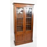 An early 20th century oak bookcase, the pair of astragal glazed doors enclosing adjustable shelves,
