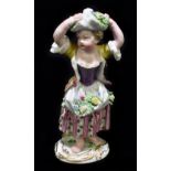 MEISSEN; an 18th century figure of a girl with flowers tied up in a bonnet upon her head, painted