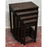 A nest of four Chinese carved hardwood coffee tables with carved skirts and legs decorated with