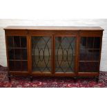 An Edwardian marquetry inlaid mahogany breakfront bookcase, with four glazed doors enclosing an