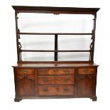 A George III oak high back dresser, the open three tier plate rack with pierced side details, on