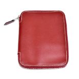 HERMÈS; a burgundy red calfskin leather card and notebook holder trimmed with white stitching and