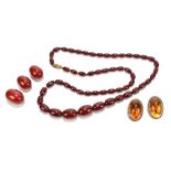 A graduated cherry amber oval bead necklace, length approx 70cm, three loose cherry amber beads