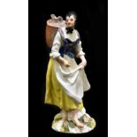 MEISSEN; an 18th century figure of a woman with basket on her back, painted marks to back of base,