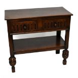 A 1920s Elizabethan style oak two tier serving table, with two drawers fitted for cutlery, on