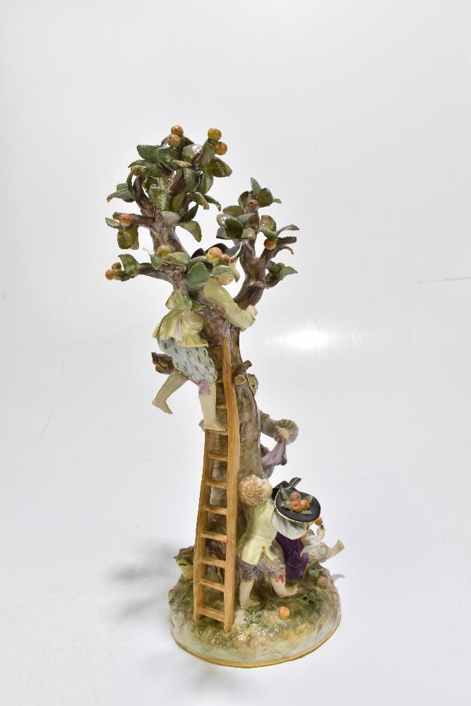 MEISSEN; an early 20th century figure group of a figure picking apples in an apple tree with three - Image 6 of 13