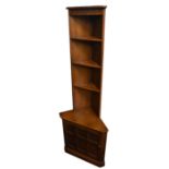 ERCOL; a medium elm free standing corner cabinet with open shelf back above single panel door,