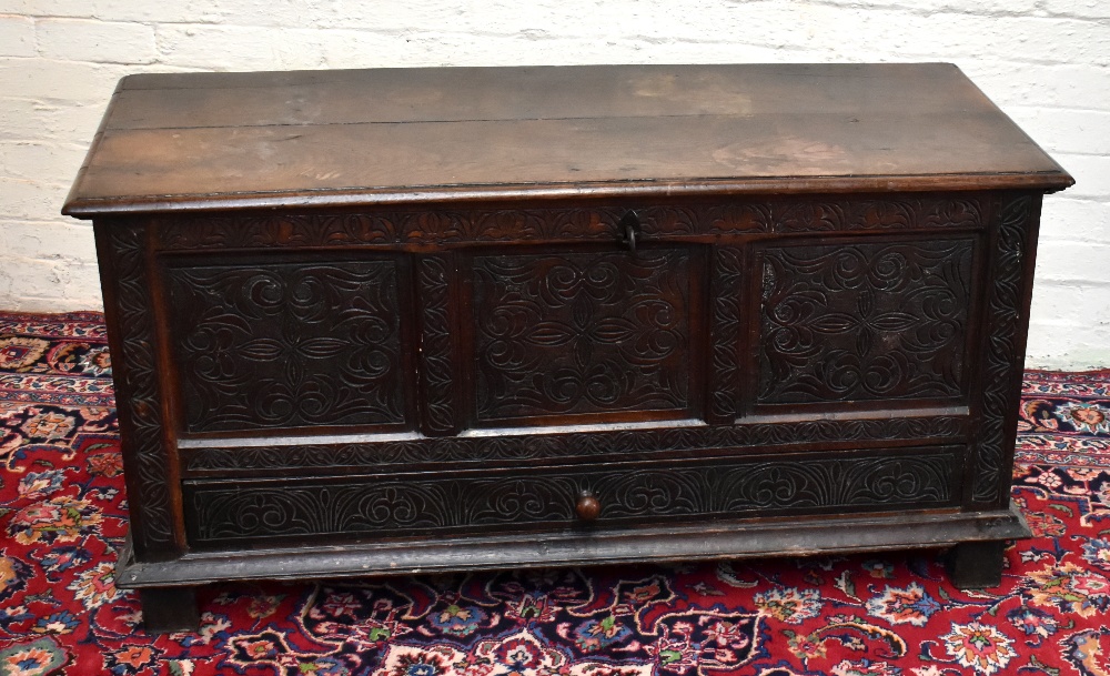 An early 18th century oak mule chest, with hinged top above a panelled front and one long drawer, on