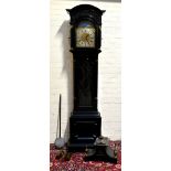 A 19th century Anglo Indian ebonised longcase clock, the moulded hood above arched dial set with