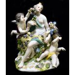 MEISSEN; an 18th century figure group with two cherubs holding garlands of flowers, painted marks to