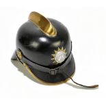 A Prussian WWI black leather helmet with brass raised central bar and applied circular badge, length